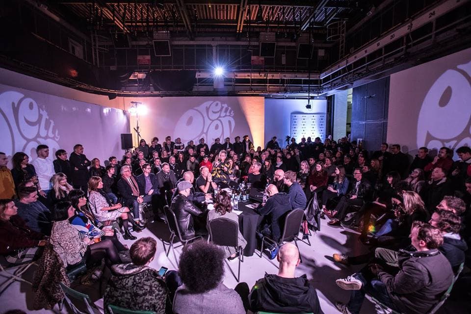A packed audience at an event in a dimly lit studio