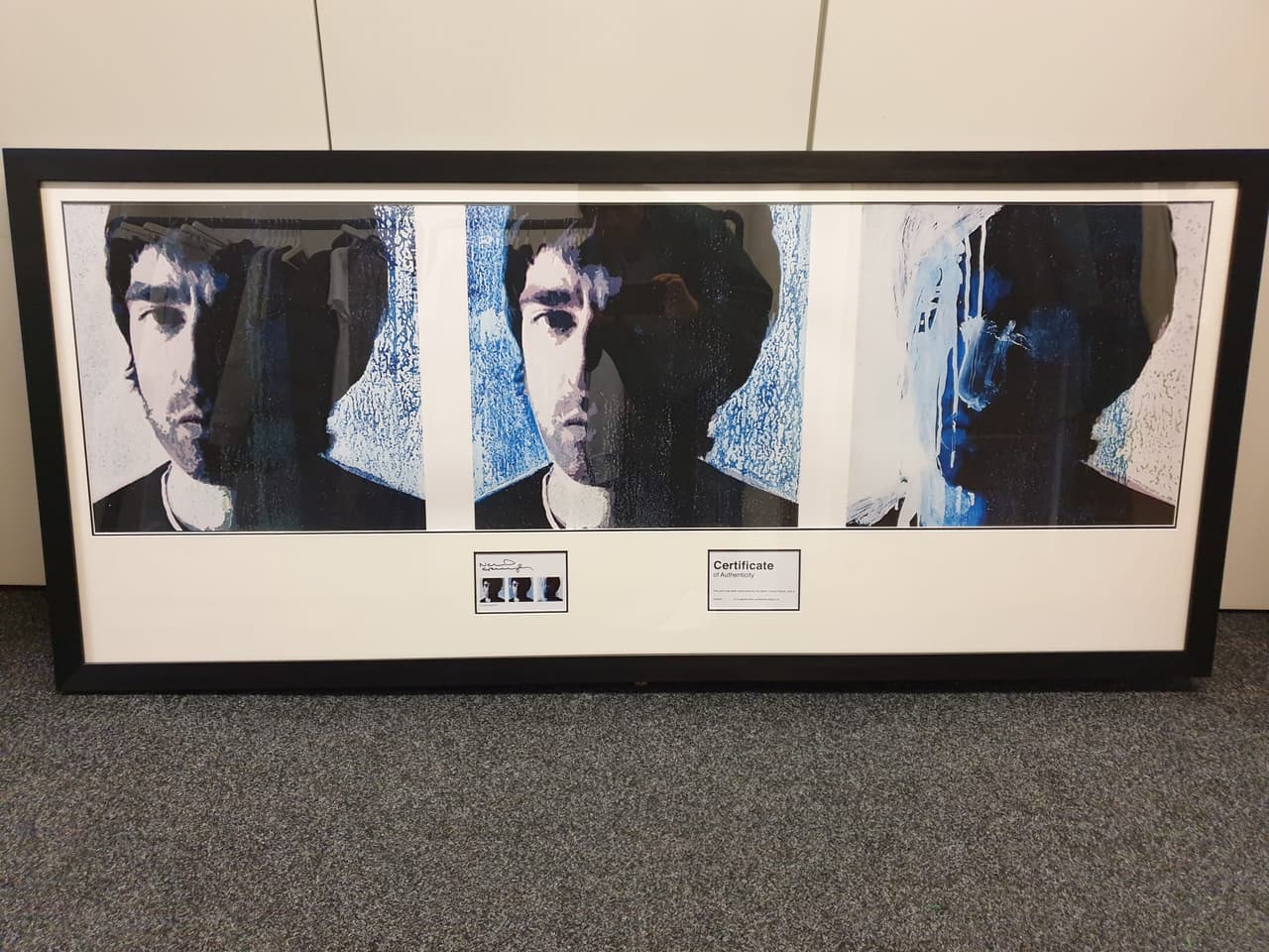 A framed triptych of blue-toned portrait prints with its certificate