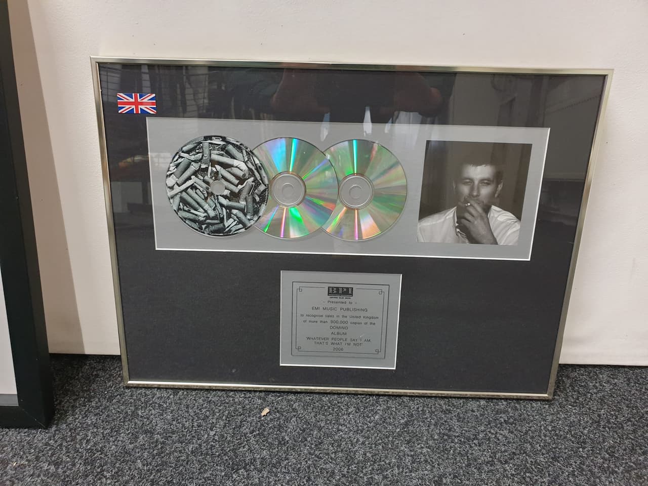 A framed disc award with CDs and a presentation plaque