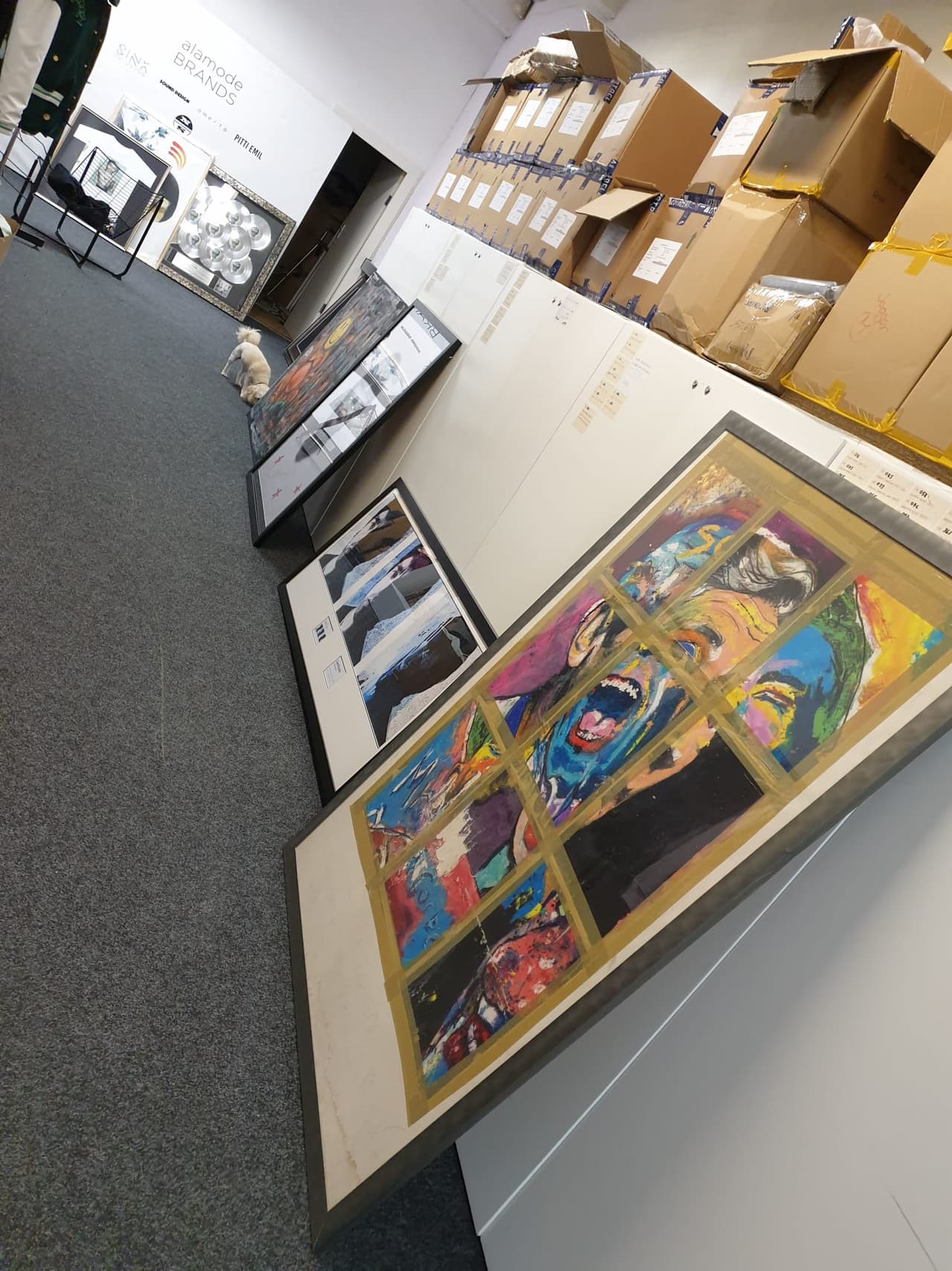 Framed artworks lined up along a wall