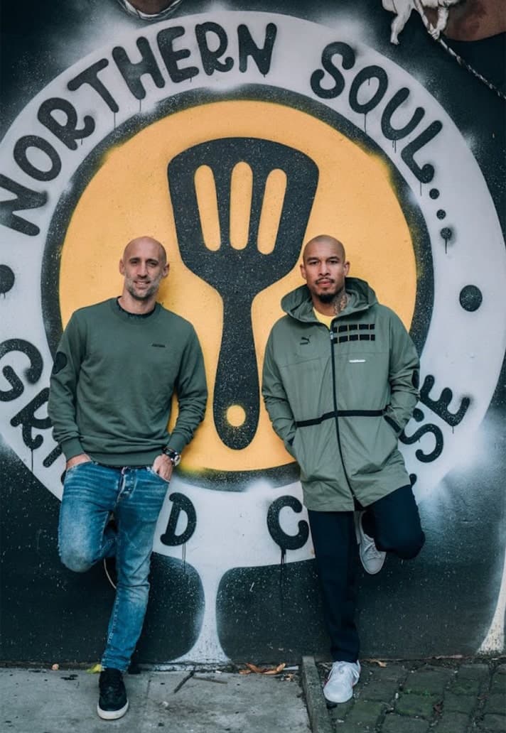 Two men in front of a Northern Soul mural