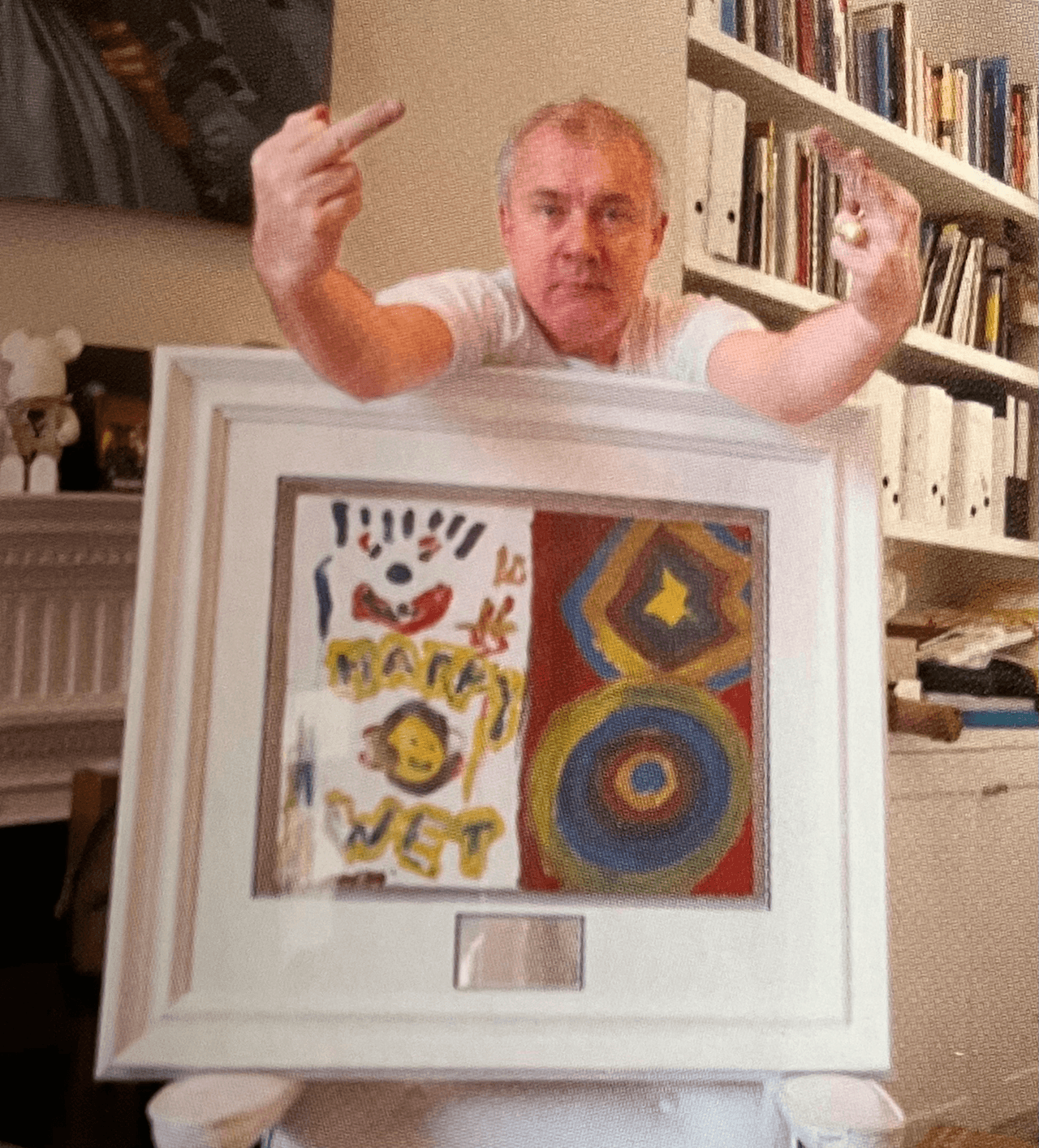 The 'Happy Wet Piss' painting, held up in its white frame