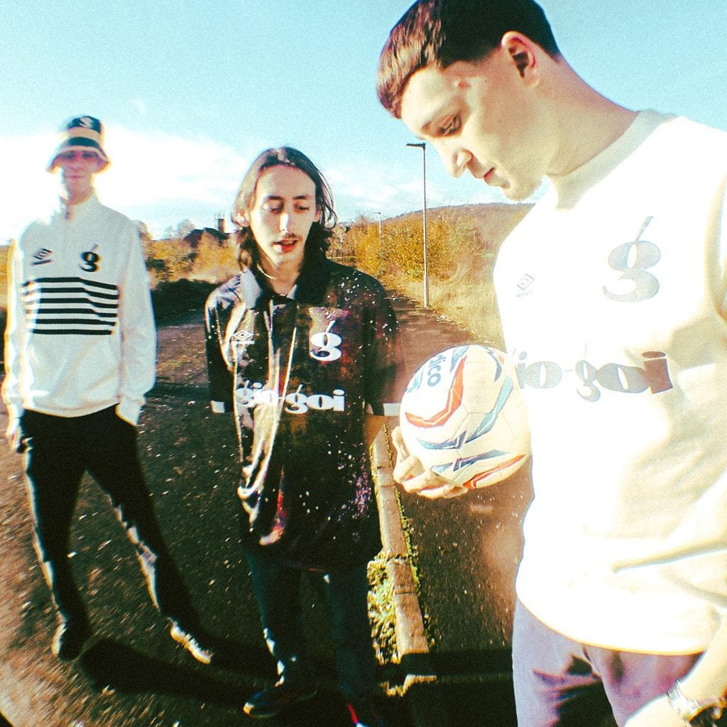 Three young men with a football, in giogoi and Umbro tops